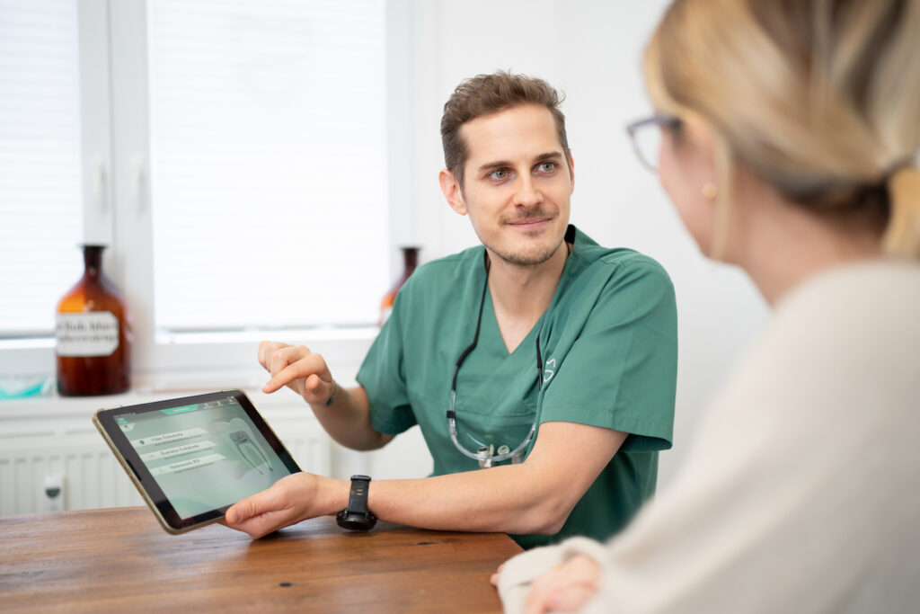 Zahnarzt und Zahntechnikermeister Maximilian Sattler berät eine Patientin worauf es bei guten Zahnprothesen ankommt.